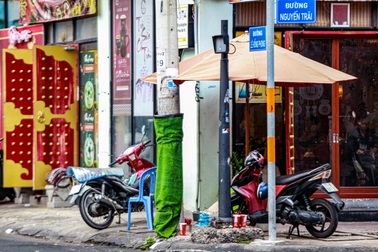 Tháo cỏ nhựa chống quảng cáo rao vặt trên cột đèn điện ở TPHCM
