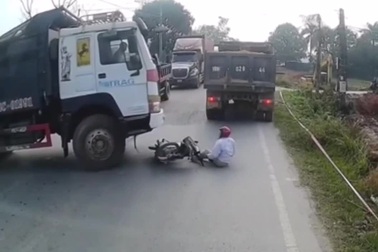 Nhặt mũ bảo hiểm bị rơi xuống đường, người đàn ông suýt mất mạng