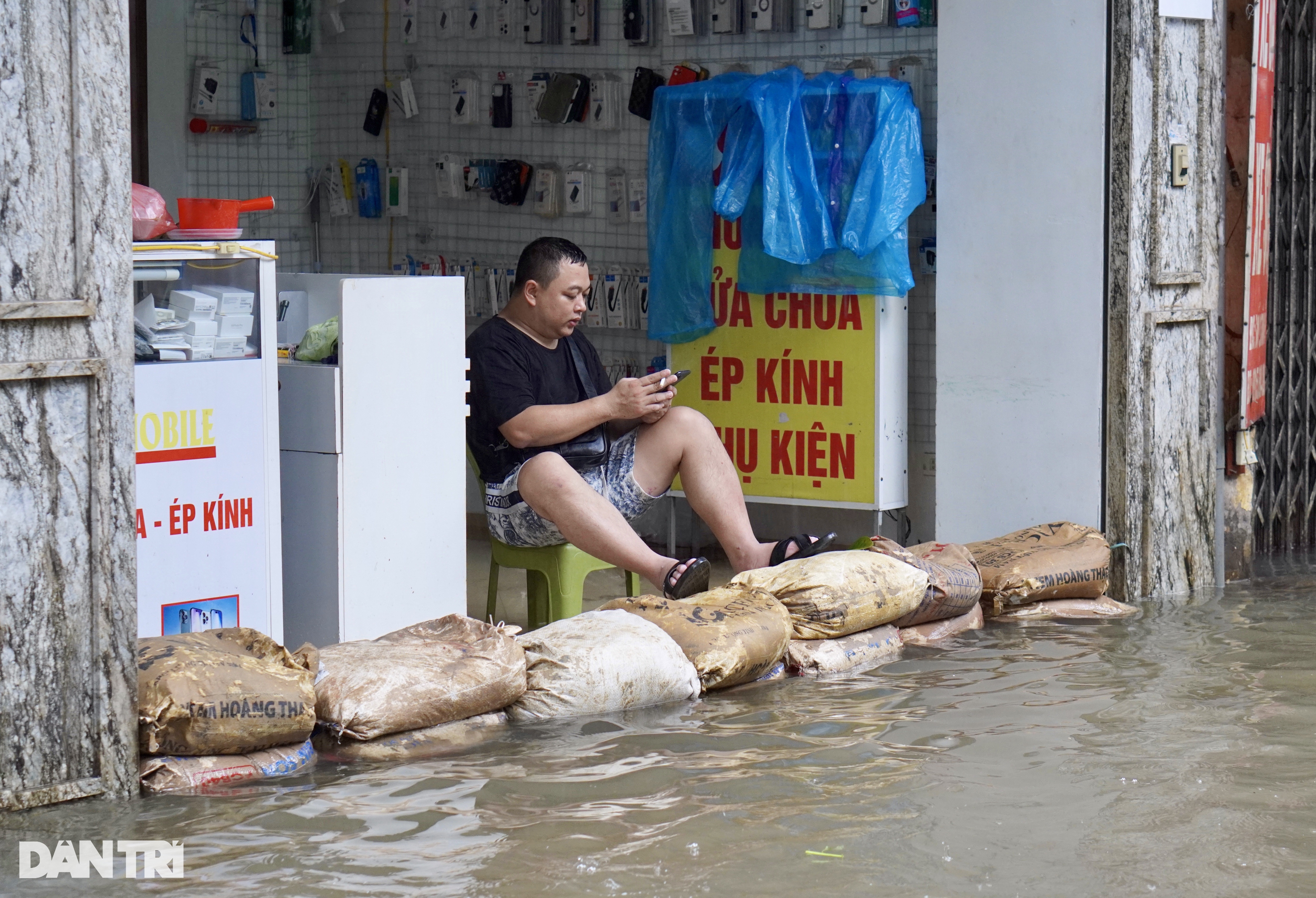 Người dân xếp chồng bao cát thành "đê" chắn trước cửa nhà (Ảnh: Thanh Thúy).