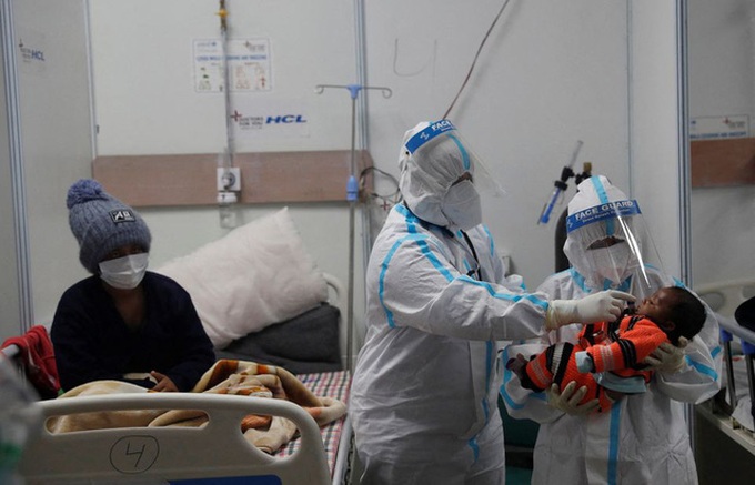 Kiểm tra nhiệt độ một trẻ sơ sinh có mẹ mắc Covid-19 ở New Delhi, Ấn Độ. Ảnh: Reuters