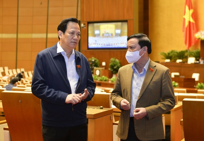 Bộ trưởng Đào Ngọc Dung trao đổi với Phó Chủ tịch Quốc hội Nguyễn Khắc Định bên hành lang Quốc hội