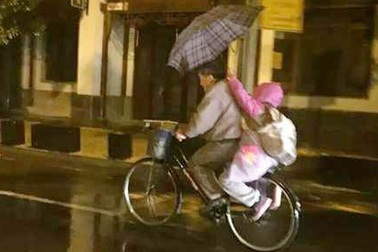 Ảnh “cháu gái dùng ô che mưa cho ông” gây xúc động dân mạng