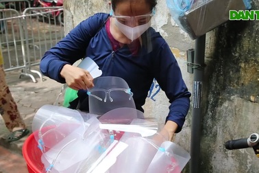 Người dân đeo khẩu trang kính chống giọt bắn đi chợ