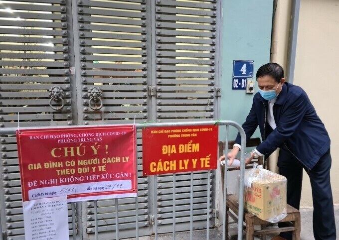 Thành viên tổ Covid cộng đồng phường Trung Văn, quận Nam Từ Liêm khử khuẩn đồ tiếp tế cho một gia đình F1 cách ly tại nhà ở đường Lương Thế Vinh.
