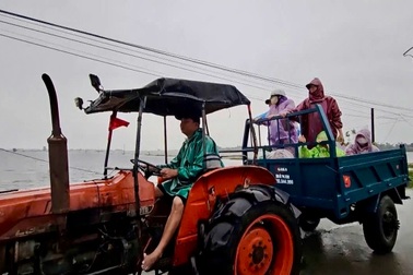 Người đàn ông dùng máy cày vượt lũ, giúp sản phụ, người bệnh đi cấp cứu