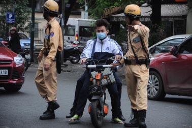 Cảnh sát giao thông "soi" nhãn vở các học sinh không đội mũ bảo hiểm