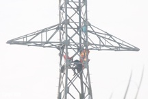 Hai người đàn ông ngồi vắt vẻo trên trụ điện cao hàng chục mét