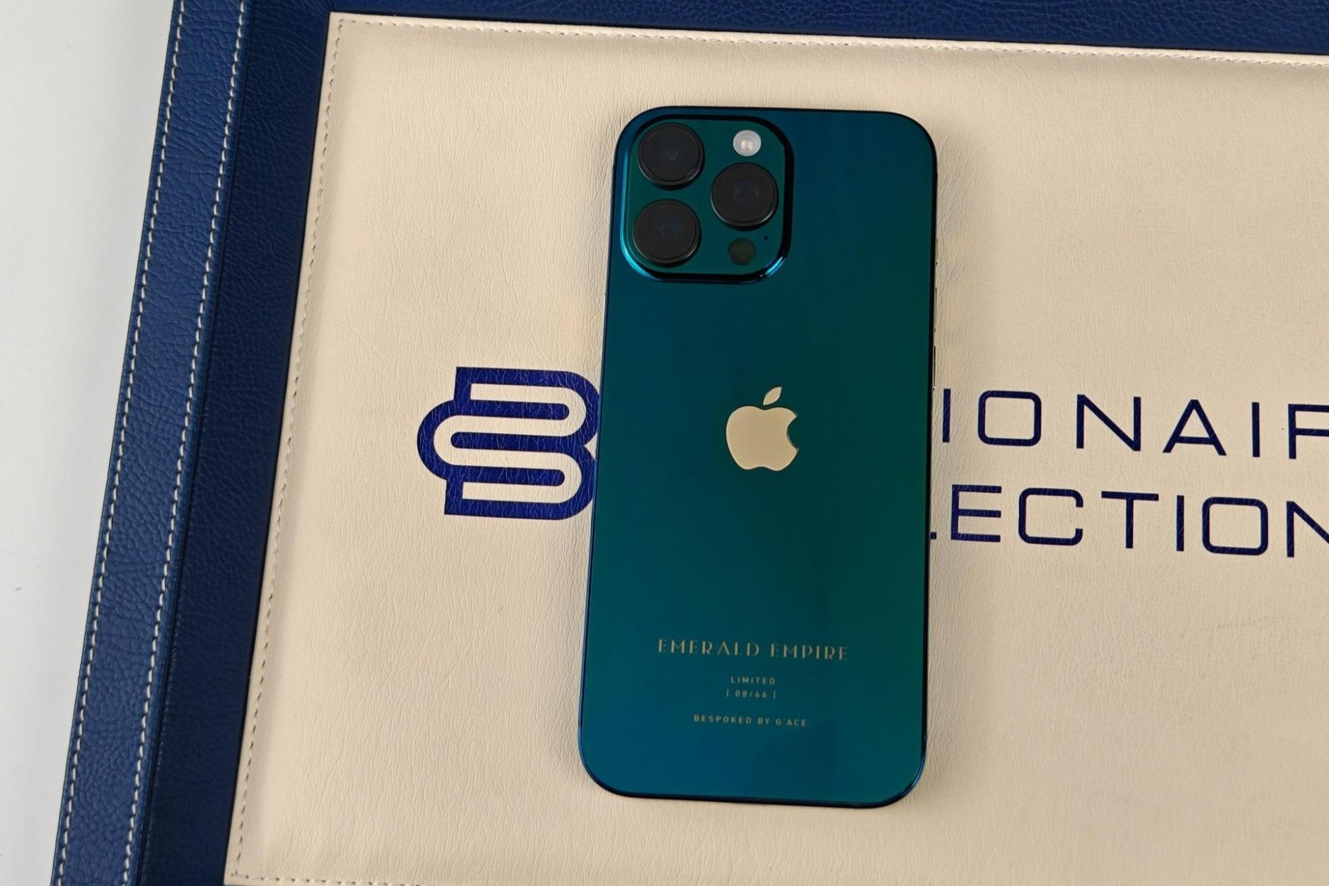 Ở ngay phía dưới logo Apple là bốn dòng chữ "EMERALD EMPIRE", "LIMITED", "xx/66" và "MADE BY G'ACE" được khắc màu vàng. Điều này nhằm nhấn mạnh tính độc đáo và số thứ tự của chiếc iPhone 16 Pro Max Emerald Empire trong lô 66 sản phẩm.