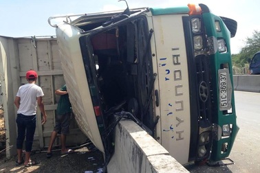 Xe tải chở đất lật nhào trên cầu Phú Mỹ trong cơn mưa nhỏ