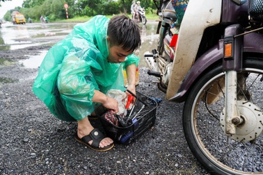 Thợ sửa xe máy kiếm bộn trong ngày mưa ngập ở Hà Nội