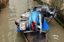 Hà Nội ngập 5 ngày chưa rút: Dân cõng con đi học, kéo xe máy bằng thuyền