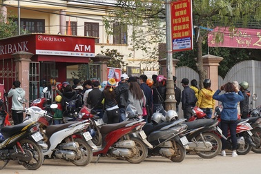 Dân quê cũng mệt mỏi xếp hàng chờ rút tiền ở cây ATM