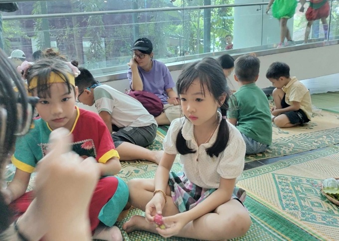 Nghệ nhân hướng dẫn các em nhỏ chơi trò chơi dân gian nặn đất