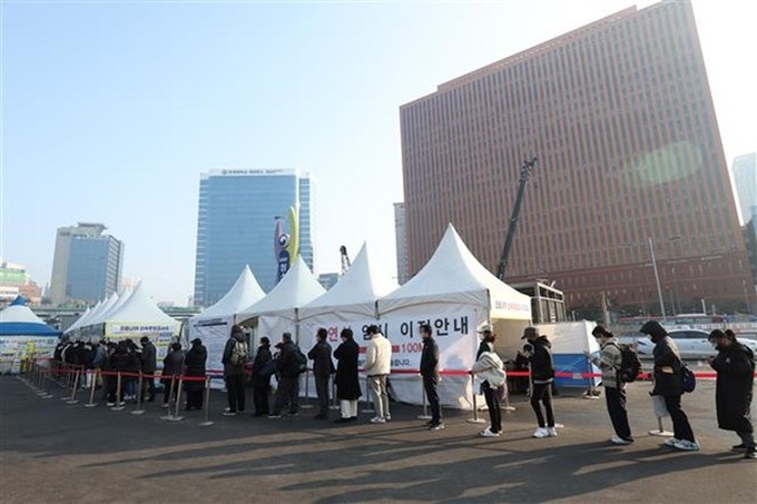 Người dân xếp hàng chờ xét nghiệm COVID-19 tại Seoul (Hàn Quốc), ngày 12/2/2022. Ảnh: Yonhap/TTXVN