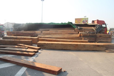 Xe đầu kéo lật nghiêng, hàng chục m3 gỗ đổ tràn trên quốc lộ