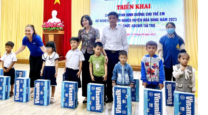 Đại diện Tổ chức AOGWR, Sở LĐ-TB&XH TP Đà Nẵng trao sữa cho trẻ em xã Hòa Nhơn. Ảnh: V.Q