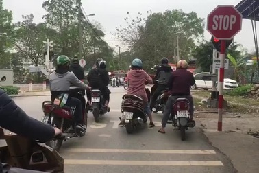 Chắn tàu đã hạ, nhiều xe máy vẫn thản nhiên băng qua đường sắt