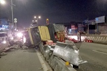 Xe tải chở bia lật ngang trên dốc cầu vượt ở TPHCM