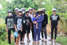 Mẹ của Lê Tuấn Khang trùm kín mặt khi người hâm mộ con trai vây quanh