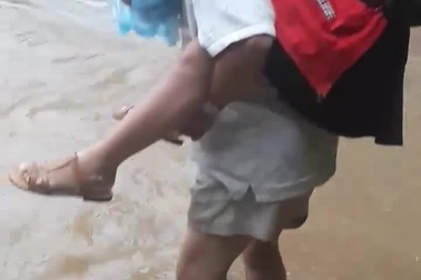 Thót tim cảnh cha cõng con băng qua dòng nước xiết