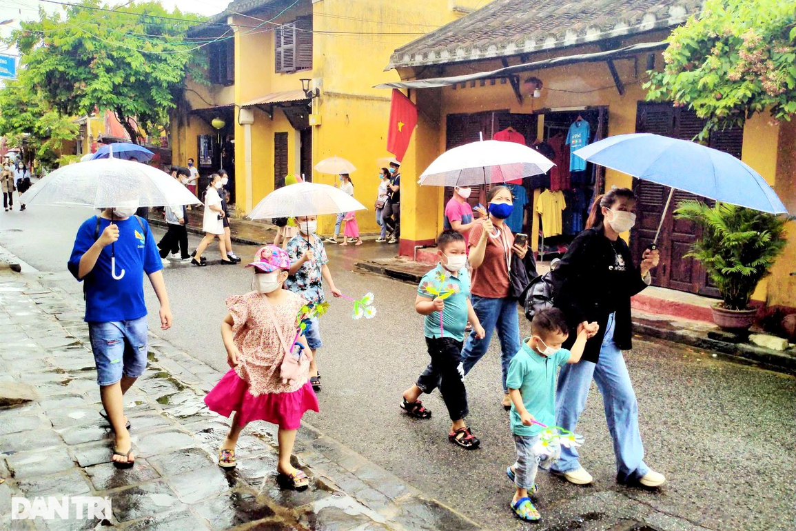 Du khách đội mưa tham quan phố cổ Hội An ngày đầu nghỉ lễ - 1