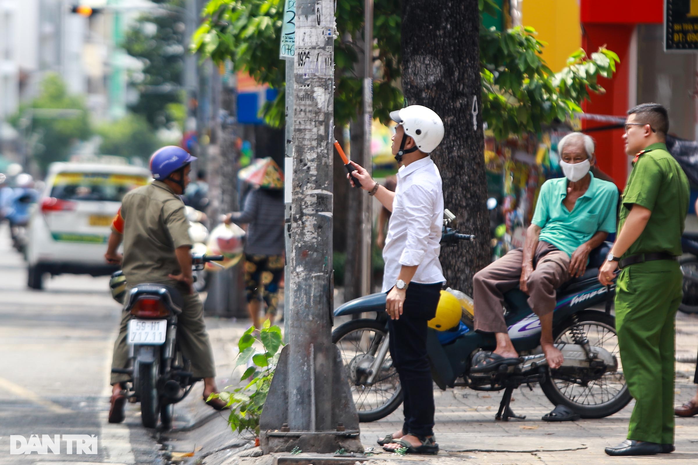 Dán quảng cáo lên cột điện TPHCM, người vi phạm bị bắt đi cạo bỏ - 2