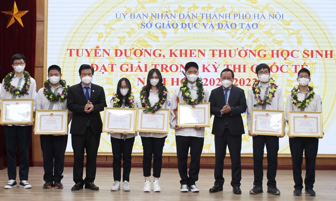Thứ trưởng Bộ Giáo dục và Đào tạo Nguyễn Hữu Độ và Phó Bí thư Thành ủy Hà Nội Nguyễn Văn Phong trao Bằng khen của UBND thành phố cho các học sinh đạt Huy chương vàng. Ảnh hanoimoi.com.vn