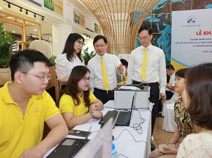 Nhân viên bưu điện hỗ trợ người dân thực hiện các dịch vụ công.