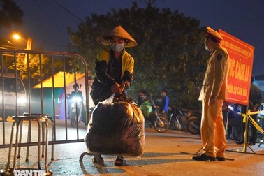 Nông dân ở khu cách ly "tất bật" chuyển rau củ qua rào sắt để bán trong đêm