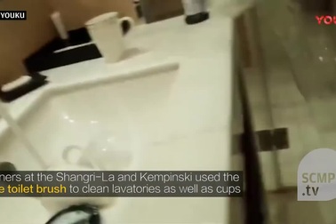 Nhân viên vệ sinh dùng cọ toilet làm sạch cốc uống nước