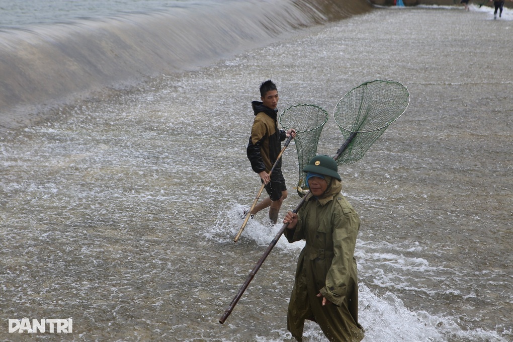 Hàng chục người liều mình lao xuống dòng nước lũ chảy xiết bắt cá - 4 Hàng chục người liều mình lao xuống dòng nước lũ chảy xiết bắt cá - 4
