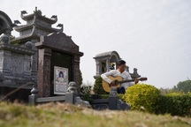 Xúc động hình ảnh người đàn ông ngồi đàn hát bên mộ vợ