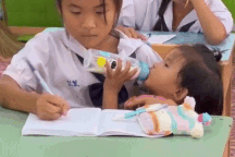 Video bé gái 10 tuổi vừa nghe giảng, vừa bế em gây xúc động