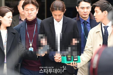 Jung Joon Young bị còng tay và áp giải đến đồn cảnh sát