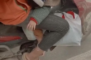 Hình ảnh người phụ nữ chở theo con nhỏ đi ship hàng gây cảm động