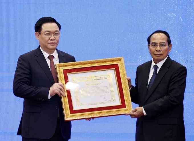 Đồng chí Bounthong Chitmany, Ủy viên Bộ Chính trị, Thường trực Ban Bí thư Lào, Phó Chủ tịch nước Lào trao Huân chương Vàng Quốc gia của Lào cho đồng chí Vương Đình Huệ, Ủy viên Bộ Chính trị, Chủ tịch Quốc hội.