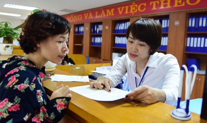 Cán bộ bộ phận “một cửa” Ủy ban nhân dân quận Long Biên, Hà Nội ân cần hướng dẫn người dân làm thủ tục hành chính.