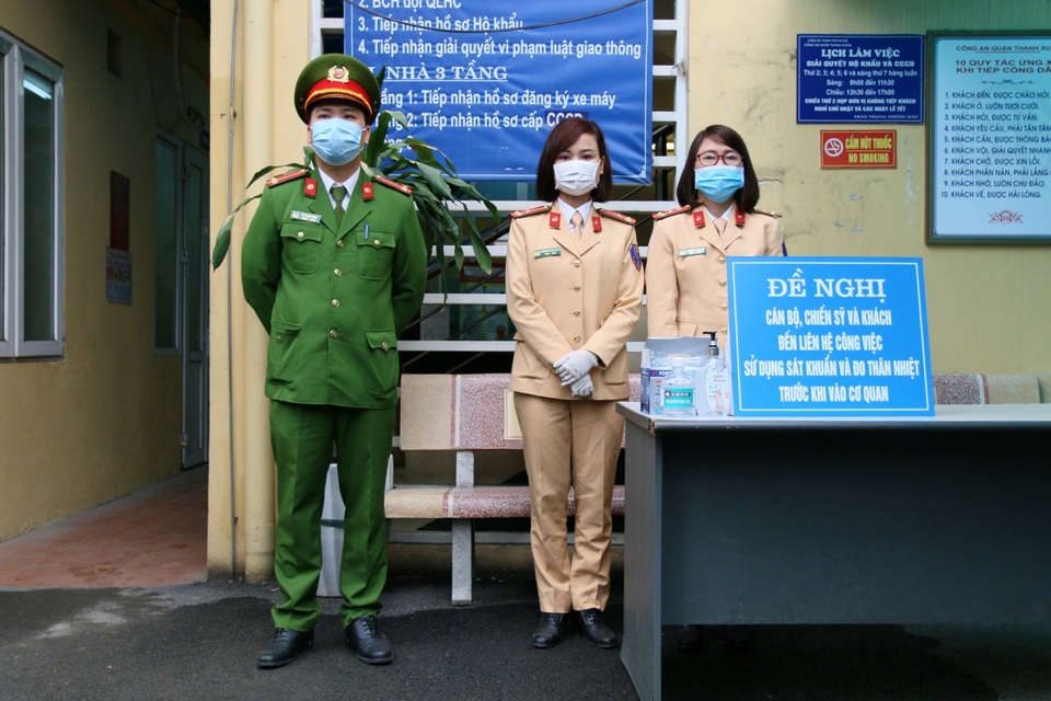 Công an Hà Nội đo thân nhiệt, phát khẩu trang cho công dân đến làm việc - 1