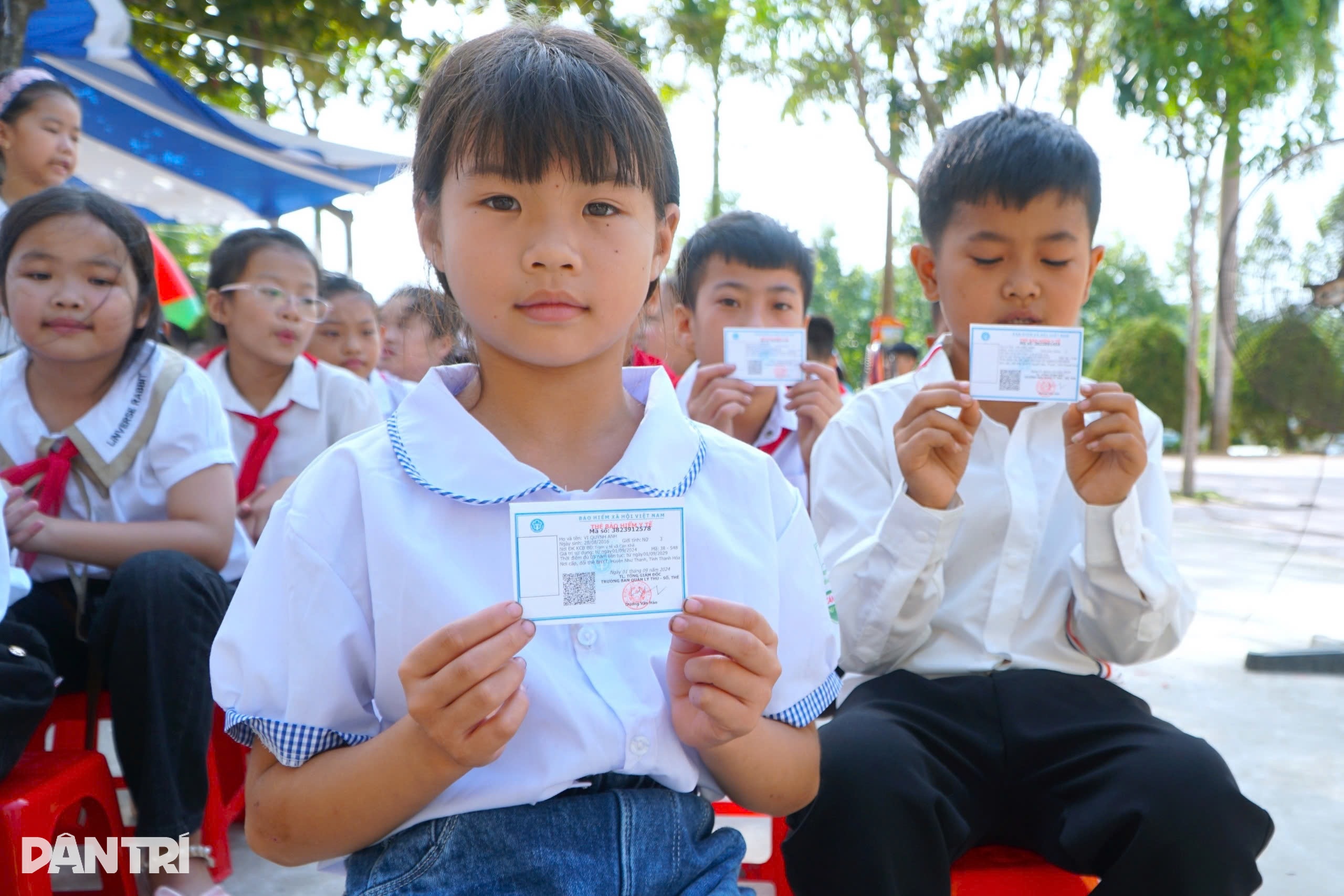 Em Vi Quỳnh Anh vui mừng đón nhận thẻ BHYT trong ngày đầu năm học mới (Ảnh: Thanh Tùng).