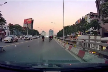 Người đi xe máy quay đầu trên cầu bị xe khác đâm ngã nhào