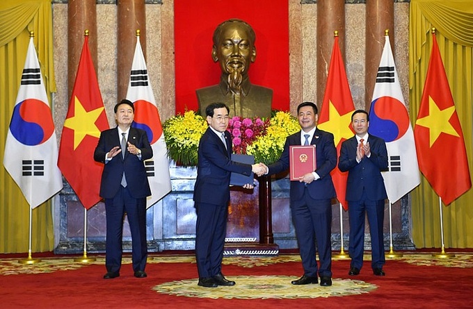 Bộ trưởng Bộ Công Thương trao văn kiện ký kết trước sự chứng kiện của Chủ tịch nước Võ Văn Thưởng và Tổng thống Hàn Quốc.
