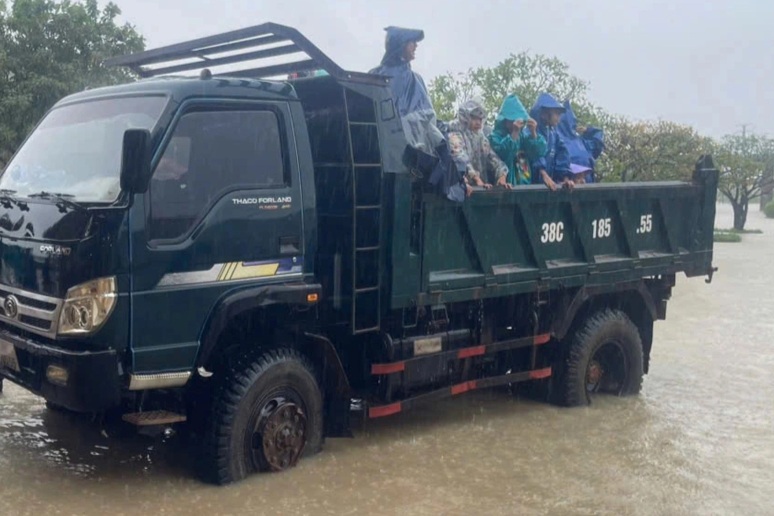 Phụ huynh dùng xe tải, thuyền thúng chở con về nhà giữa mưa lớn