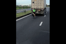 Rùng mình người đi xe đạp bám đuôi xe container trên quốc lộ