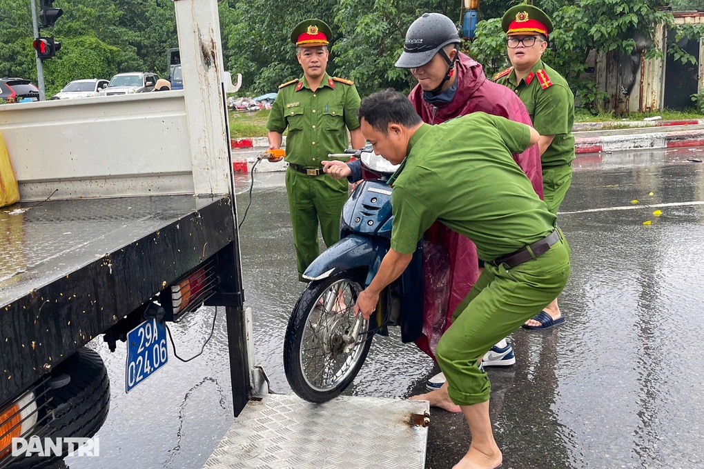 Công an đội mưa giúp dân qua những điểm ngập sâu ở Hà Nội - 1 Công an đội mưa giúp dân qua những điểm ngập sâu ở Hà Nội - 1