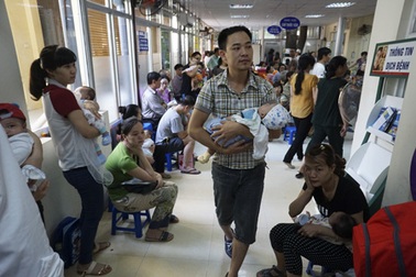 Bồng bế xếp hàng chờ tiêm phòng cho trẻ