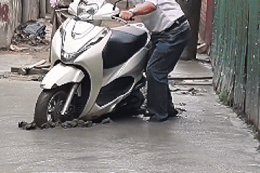 Hà Nội: Người đàn ông mắc kẹt khi cố đi xe vào đường mới đổ bê tông