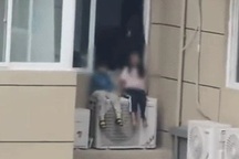 Phẫn nộ vợ bắt 2 con ngồi lơ lửng ngoài cửa sổ chung cư vì giận chồng