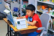 Mẹ cho con trai vừa học, vừa đạp máy may để rèn sự tập trung