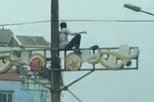 Nam thanh niên nghi ngáo đá ngồi vắt vẻo trên cột điện