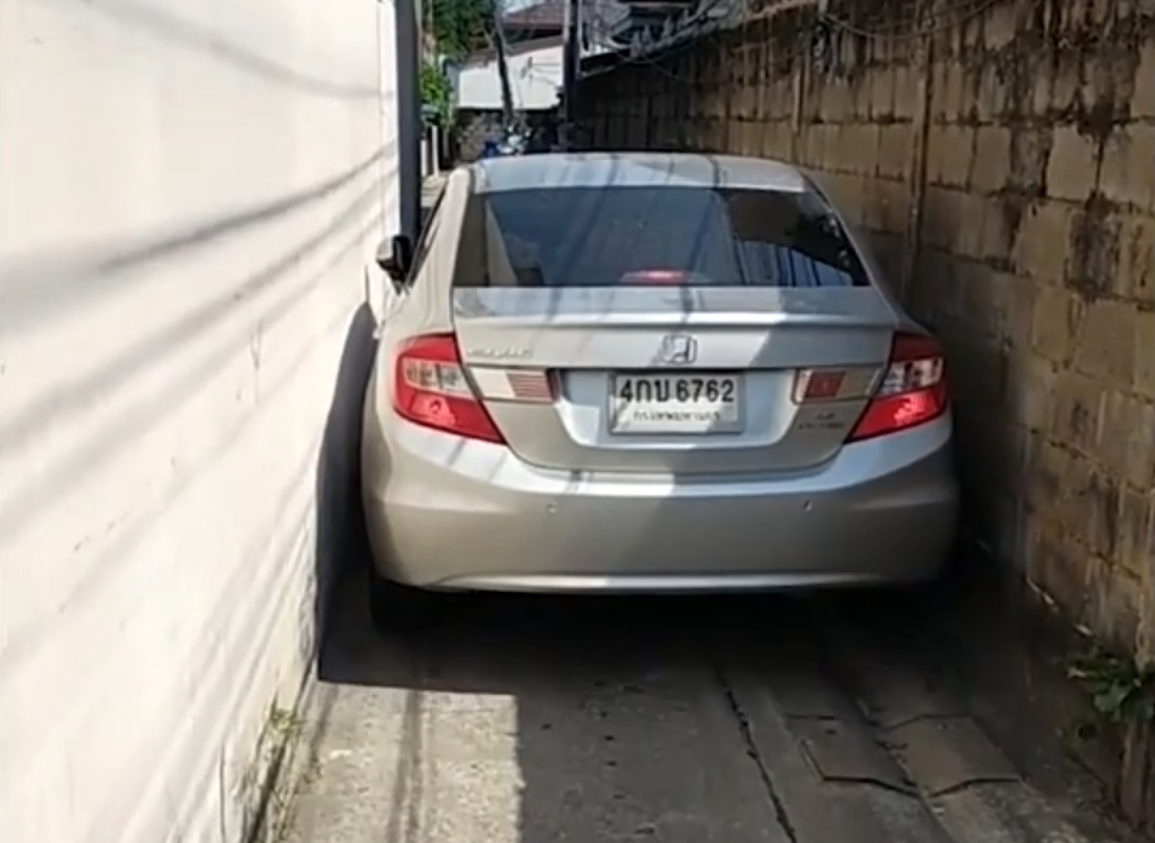 Nữ tài xế điều khiển xe đi qua con hẻm hẹp mà không gây ra bất kỳ vết trầy xước nào (Ảnh cắt từ clip). Nữ tài xế điều khiển xe đi qua con hẻm hẹp mà không gây ra bất kỳ vết trầy xước nào (Ảnh cắt từ clip).
